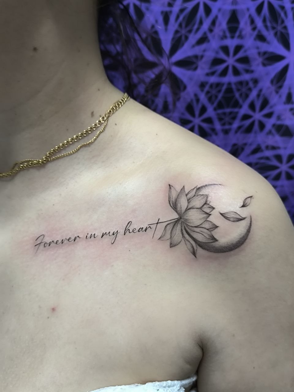 Лотос и надпись у ключицы — работа студии CosmoTattoo